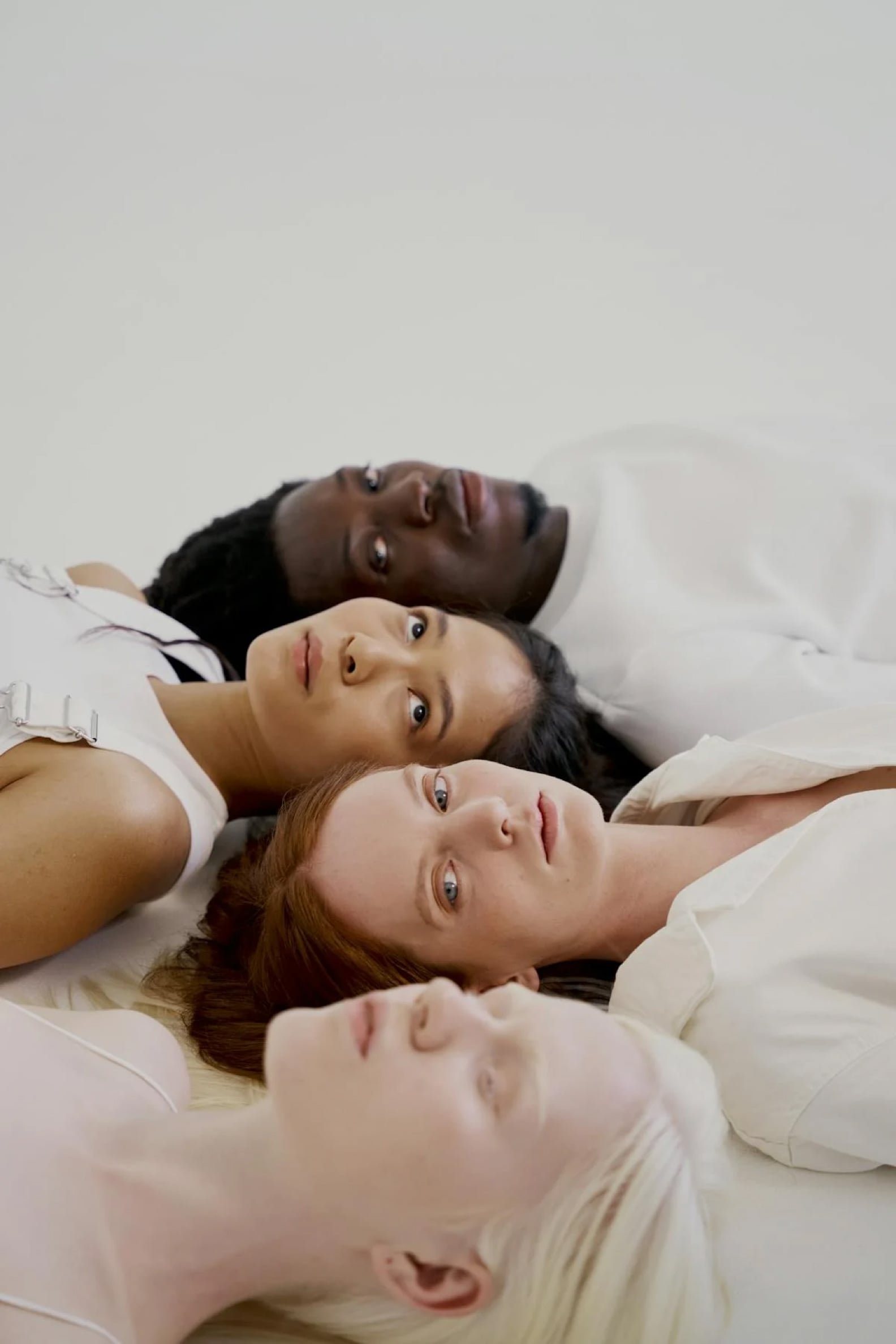 women and man lying on white surface 10211662